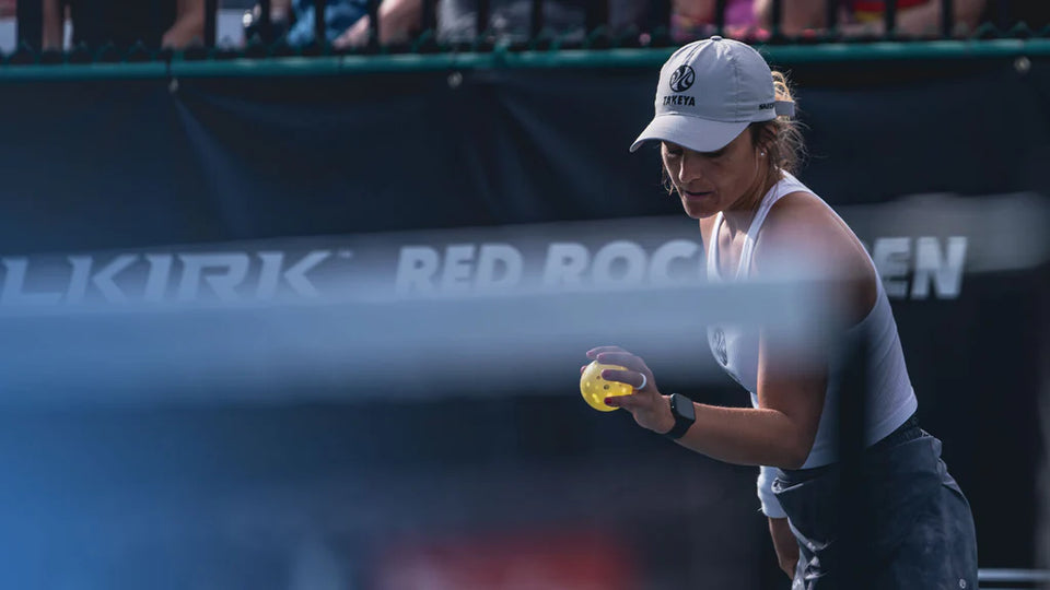 Catherine Parenteau preparing to serve a pickleball during a match.