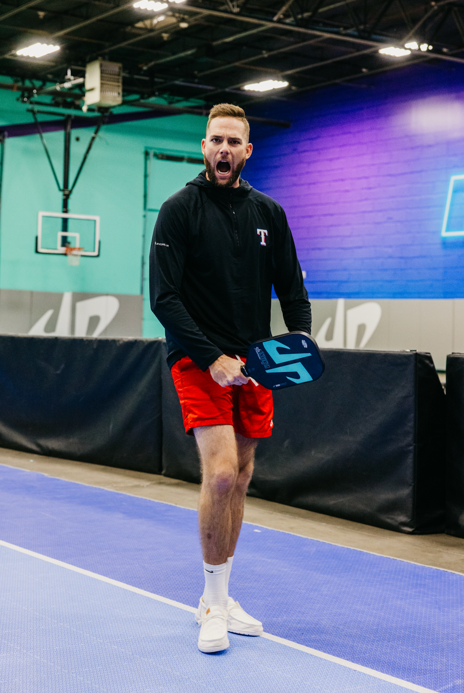 Cory Cotton celebrating with the SLK by Selkirk x Dude Perfect Trickshot paddle on a pickleball court