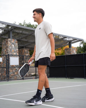 A man wearing a Selkirk TruWear Men's Cardinal Workout Shirt while playing pickleball.