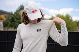 Model wearing Selkirk TruWear Men's Cardinal Long Sleeve Workout Shirt, showing logo on sleeve.