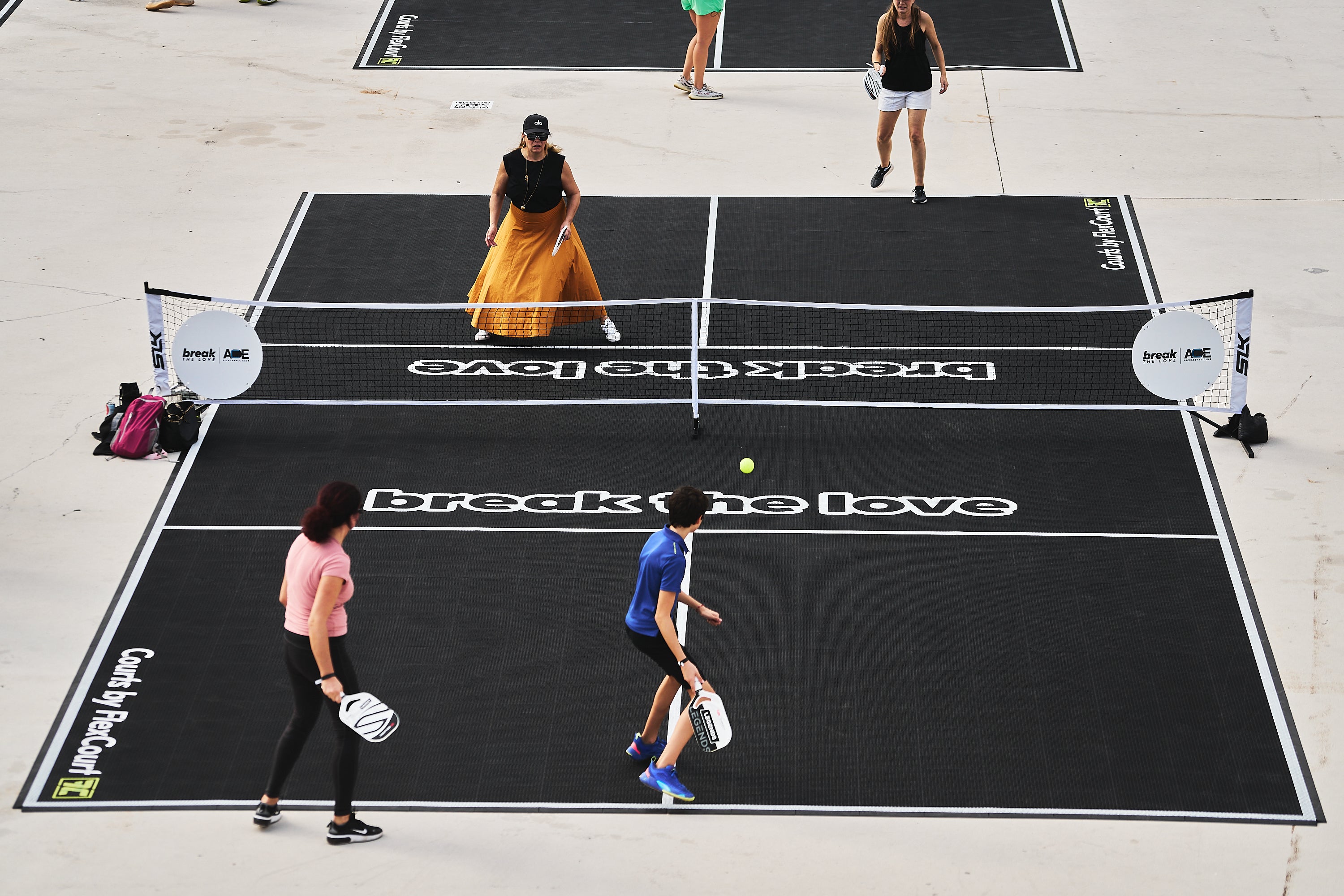 Players participating in a pickleball match at the PICKLEBASEL event, with a focus on the court and players.