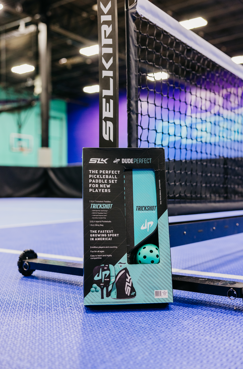 SLK by Selkirk x Dude Perfect Trickshot paddle box on a pickleball court