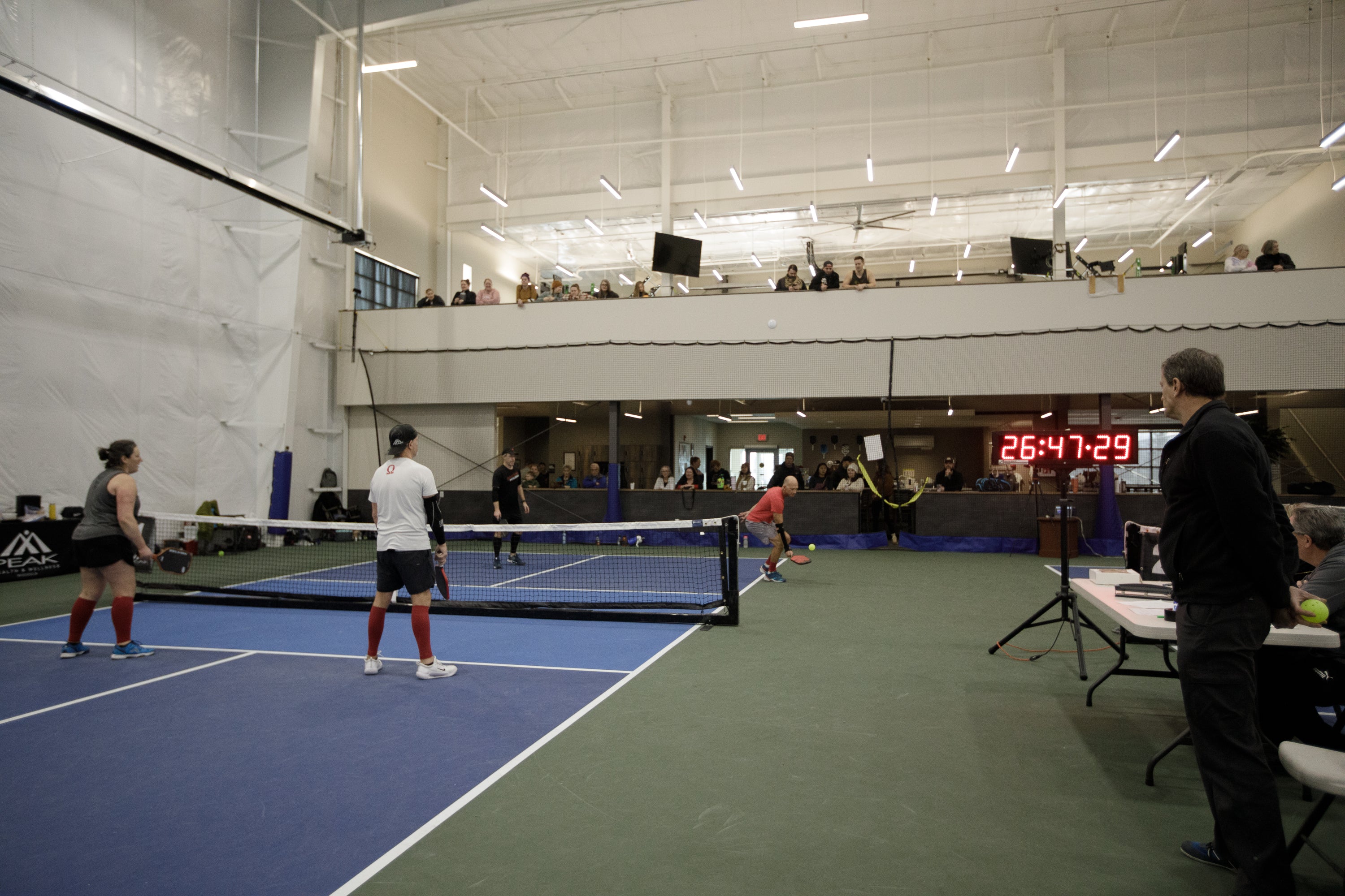 Players participating in a pickleball game during a Guinness World Record attempt, with a timer showing 26:47:29.