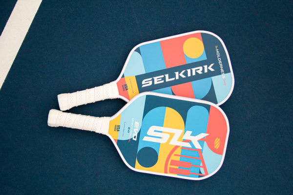 Two SLK by Selkirk EVO 2.0 pickleball paddles with colorful designs and grips.