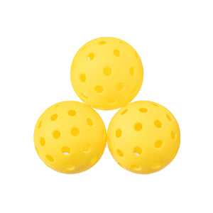 Three yellow pickleballs with holes, used for pickleball.