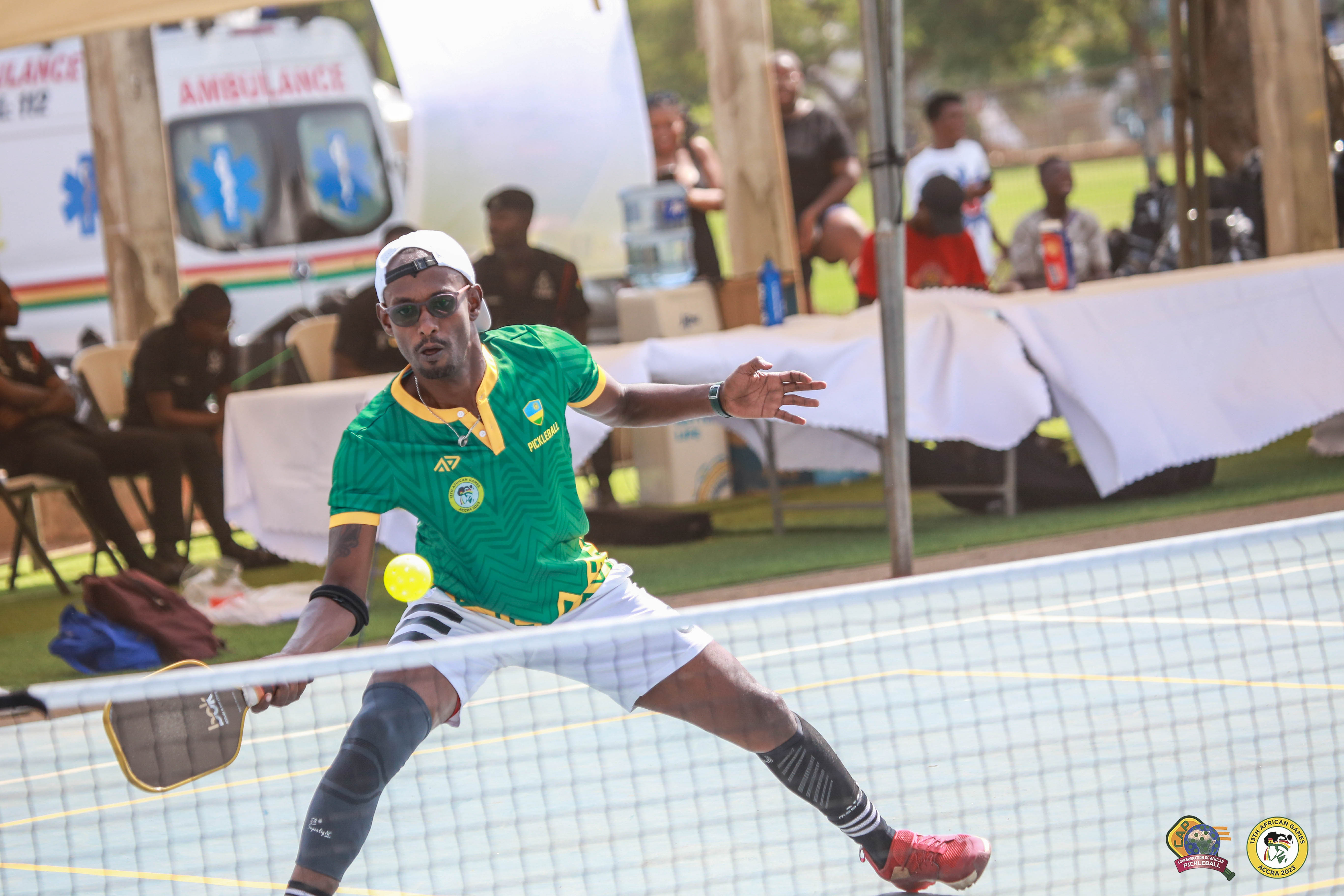 A player in a green jersey competes in pickleball at the 13th African Games.
