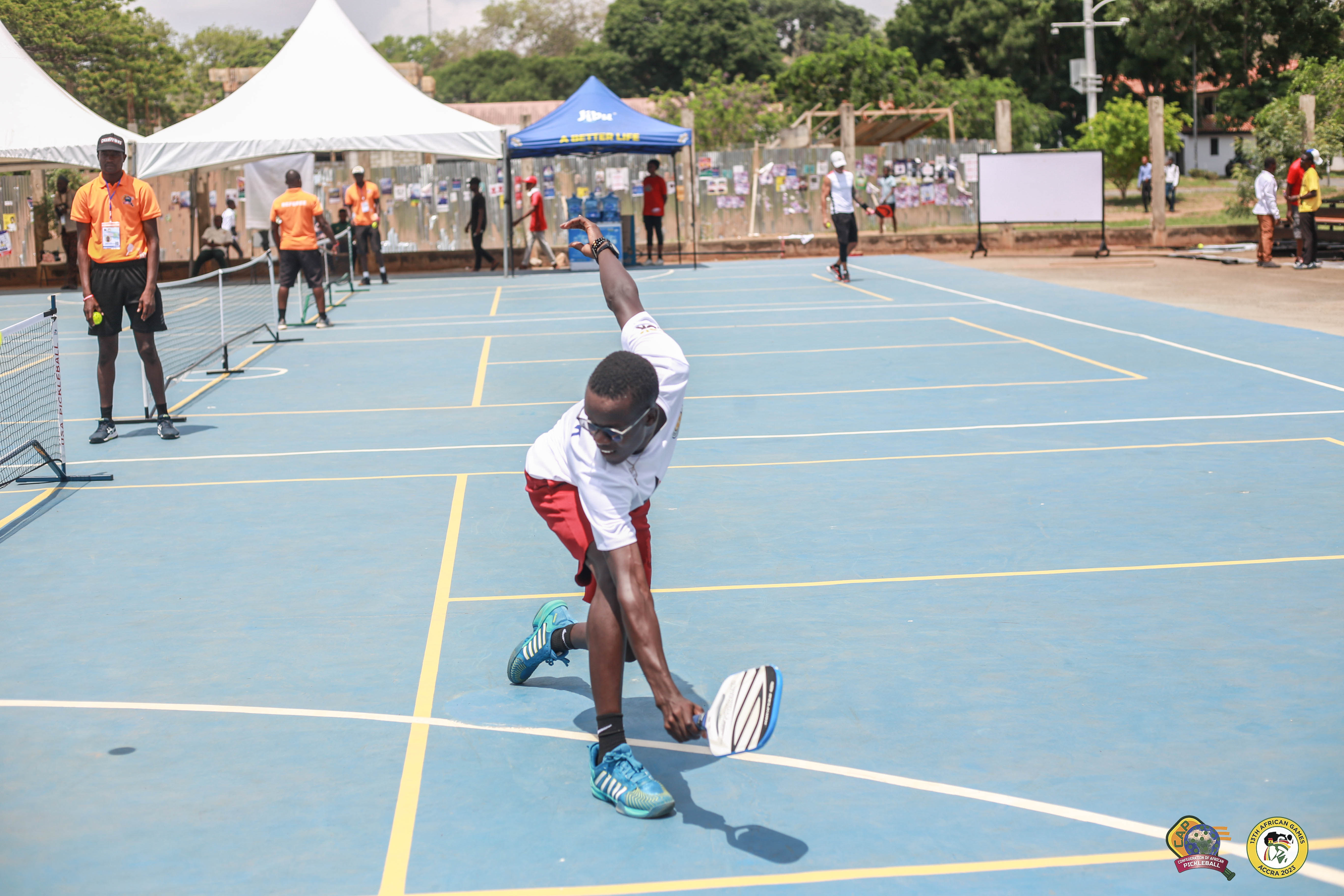 A player competing in pickleball at the 13th African Games, using a Selkirk Power Air Invikta paddle.