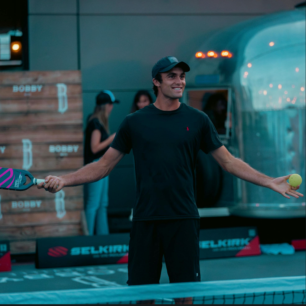 James Ignatowich holding a pickleball paddle and ball at a pickleball event in Nashville