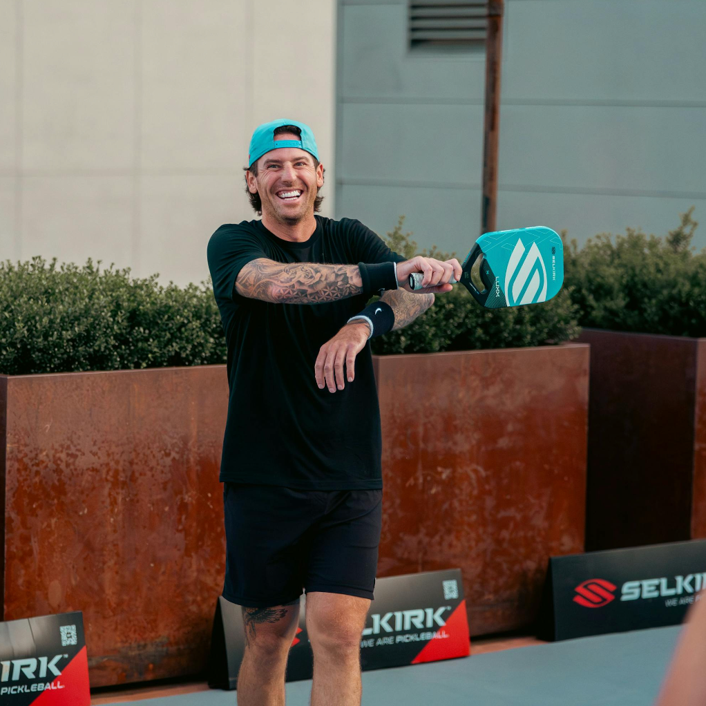 James Neal smiling while holding a pickleball paddle on the court