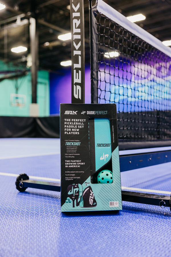 SLK by Selkirk x Dude Perfect Trickshot Pickleball Bundle packaging on a court