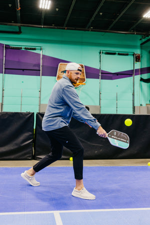 Player swinging SLK by Selkirk x Dude Perfect Evo 2.0 Control Max pickleball paddle on court