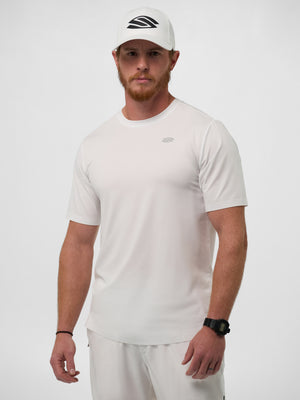Red-bearded male model wearing white performance tee and matching white cap with black stylized 'S' logo