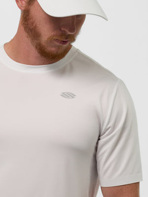 Man wearing white performance T-shirt and white cap; small gray logo on left chest, cropped at shoulders.