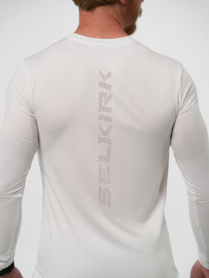Back view of man wearing white long-sleeve shirt with vertical perforated "SELKIRK" logo down the spine.