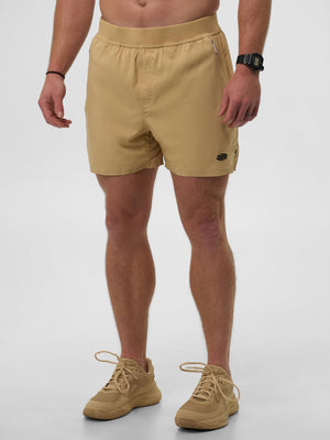 Model wearing Sandstorm Men's Pro Line 5" shorts in beige color