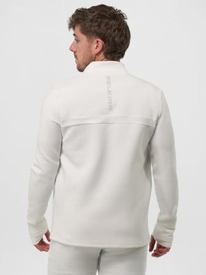 Man seen from back wearing white jacket with vertical SELKIRK logo on upper back