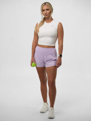 Model wearing Women's Pro Line Woven Pickleball Shorts in lavender, holding a pickleball.