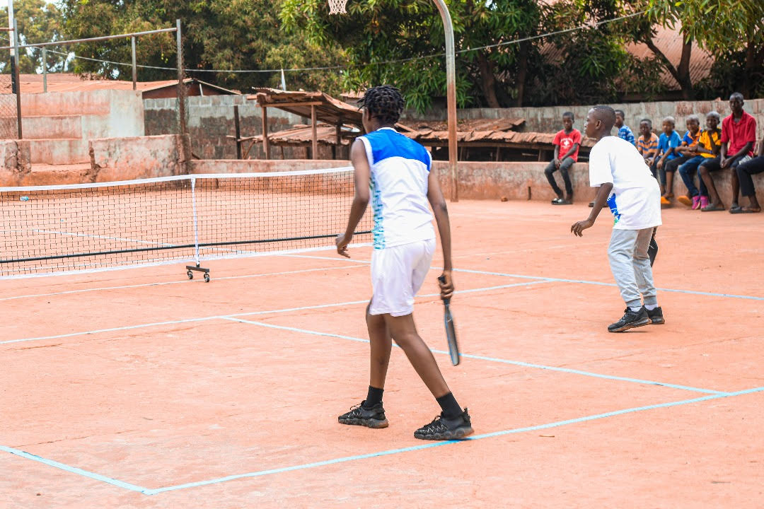 Two children playing pickleball on a court at the Sierra Leone Mission School