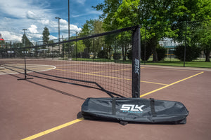 SLK Pro Portable Pickleball Net with carry bag on a court