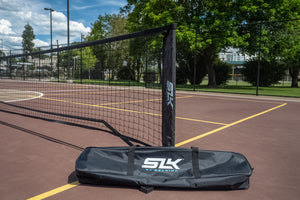 SLK Pro Portable Pickleball Net with carrying bag on a court