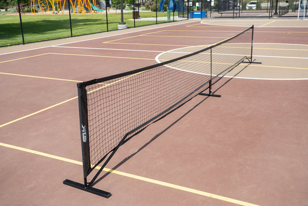 SLK Pro Portable Pickleball Net set up on a court with a black frame and netting.