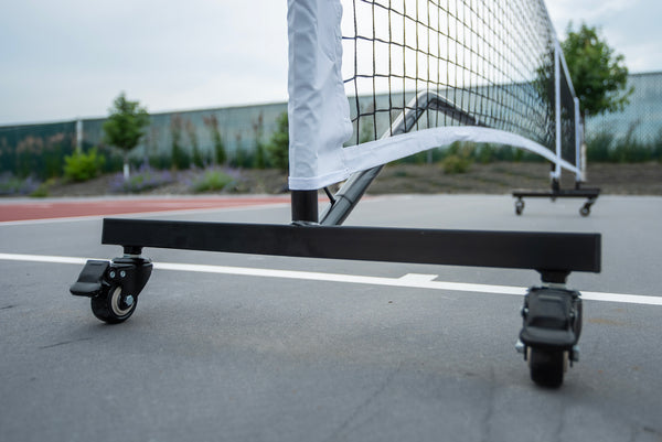 SLK Prime Portable Pickleball Net with wheels on a court