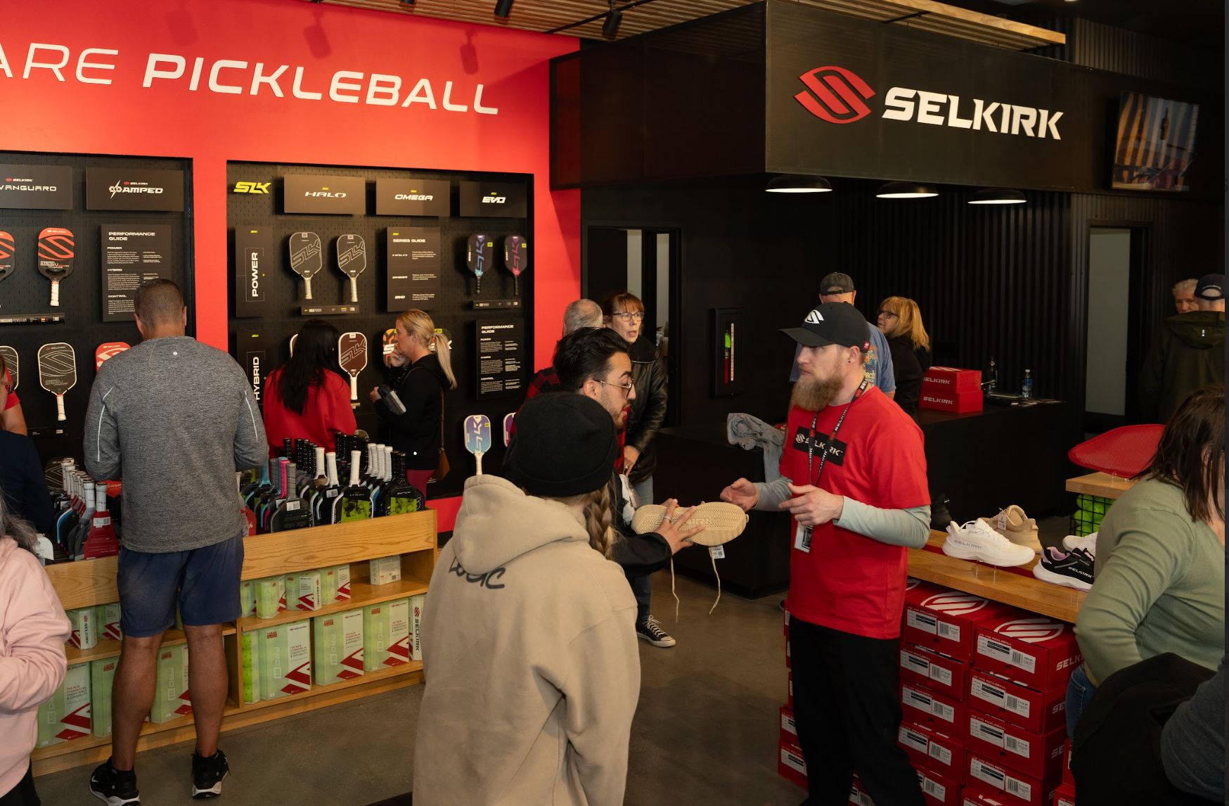 A Selkirk employee helps a customer find a pair of court shoes inside the Selkirk Pro Shop. 