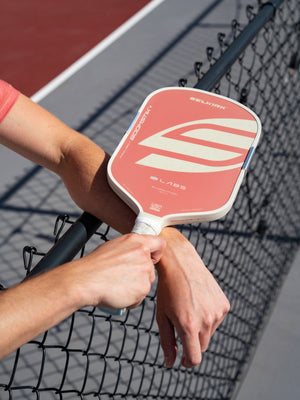 Player resting a Boomstik Canyon Clay paddle on the net