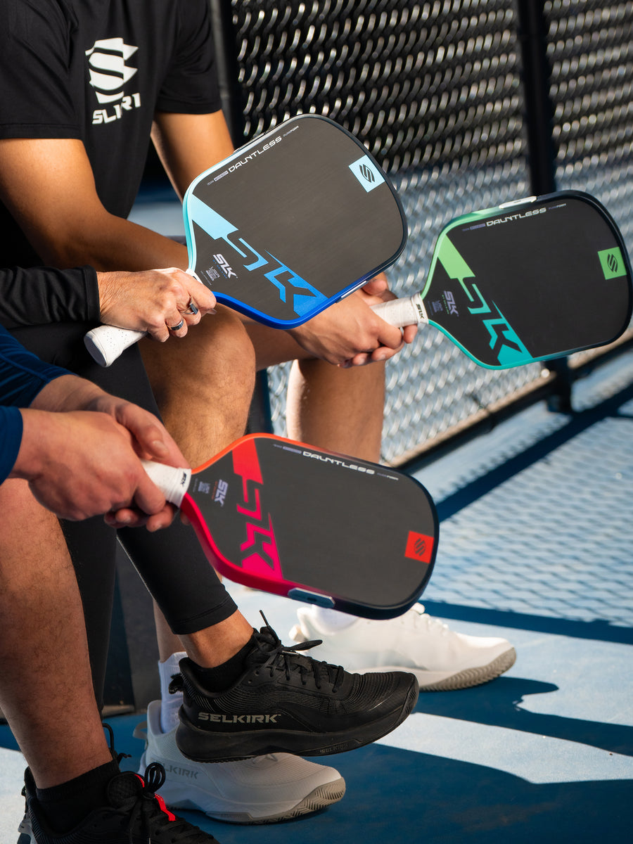 3 people sit courtside with new SLK paddles