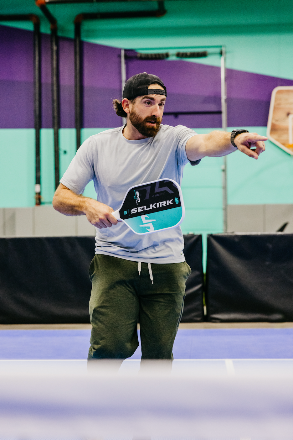 Cory Cotton demonstrating the SLK by Selkirk x Dude Perfect Trickshot paddle on a pickleball court