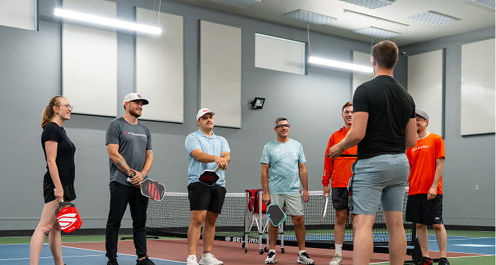 Group of people playing paddleball in a Selkirk indoor sports facility.