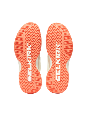Pair of coral-orange shoe outsoles with SELKIRK logo on textured herringbone tread