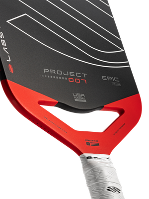 Angled close-up of Selkirk LABS Project 007 Epic 10mm pickleball paddle showing black face, red throat cutout, and white grip