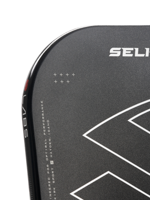 Close-up of a Selkirk paddle edge showing 'SELI' logo, 'LABS' on the rim and text 'ENGINEERED FOR OPTIMAL PERFORMANCE HAYDEN IDAHO'