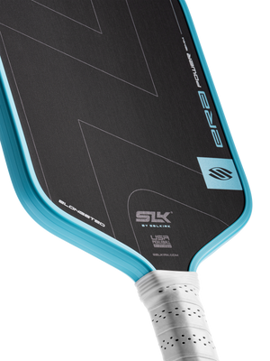 Elongated pickleball paddle with turquoise edge and black face showing SLK BY SELKIRK, ERA POWER, USA PICKLEBALL, SELKIRK.COM