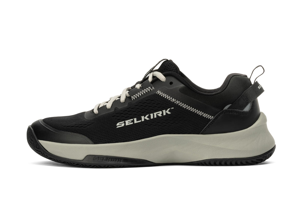 Black and gray low-top athletic shoe, right-side profile, fabric upper and chunky gray midsole; brand name SELKIRK on side.