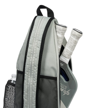 Three-quarter view of Core Line pickleball sling bag with two paddles, mesh side pocket, and top loop on white background