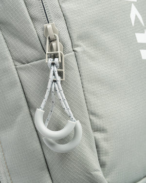 Close-up of the gray-green Core Line Pickleball Sling Bag showing double crescent zipper pulls and textured fabric