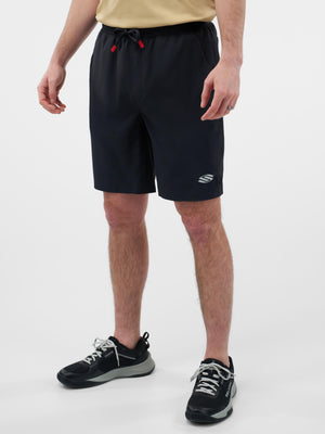 Male model wearing black drawstring athletic shorts with small logo on left hem, cropped mid‑torso to shoes.