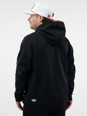 Back view of a man wearing a black hooded sweatshirt and white baseball cap, small white logo at lower hem.