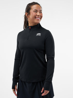 Woman wearing black quarter-zip athletic top with white SEALSKINZ logo, long sleeves with thumbholes