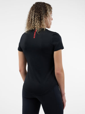 Back view of person wearing black short-sleeve athletic tee with red vertical 'CRAFT' tag at upper back and black leggings.