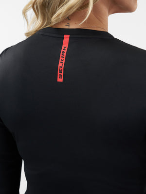 Back view of a black long-sleeve shirt with a vertical red SELKIRK logo at the nape