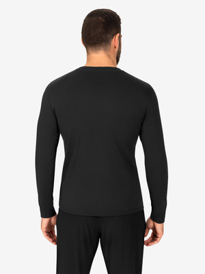 Male model seen from the back wearing a black long-sleeve t-shirt and black pants, standing against a light gray background.