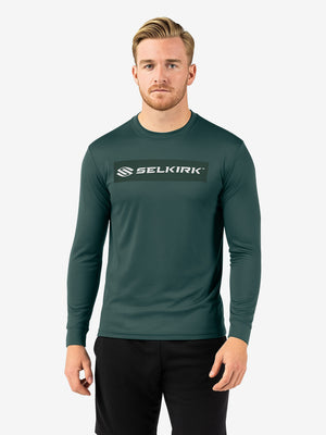 Male model wearing dark green long-sleeve crew shirt with 'SELKIRK' logo centered on chest