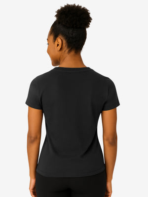 Back view of woman wearing a black fitted short-sleeve T-shirt and black leggings