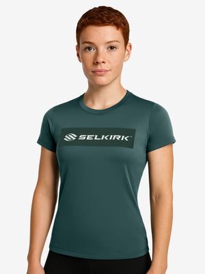 Woman wearing dark green short-sleeve tee with SELKIRK logo in white centered on chest